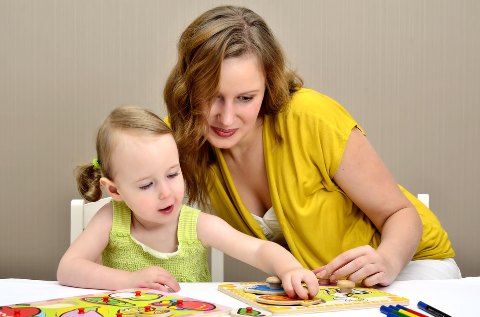 Dziewczynka i mama układają puzzle